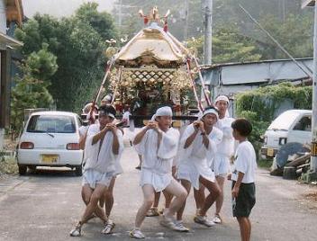 田井白鳥神社祭の神輿を担いで歩く人々の写真
