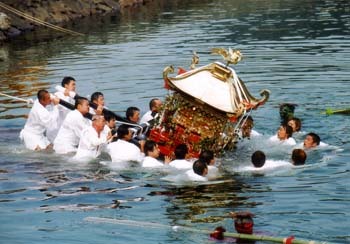 西由岐八幡神社の祭りで神輿を担いだ人々が海に入る写真